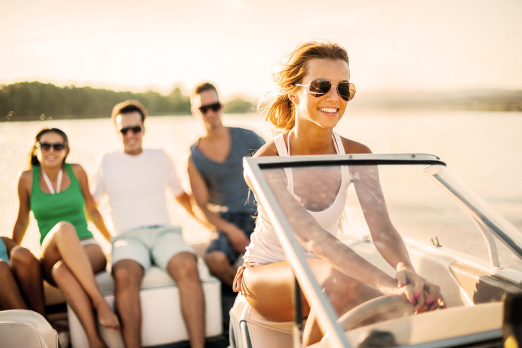 Women driving boat on water with friends